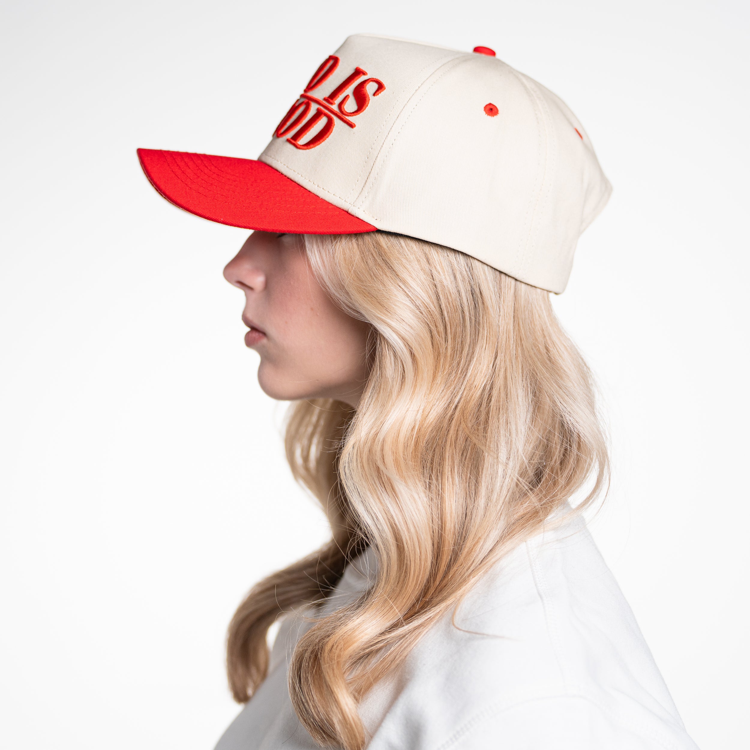 Left profile of woman modeling God Is Good Hat, showcasing breathable mesh and curved brim design